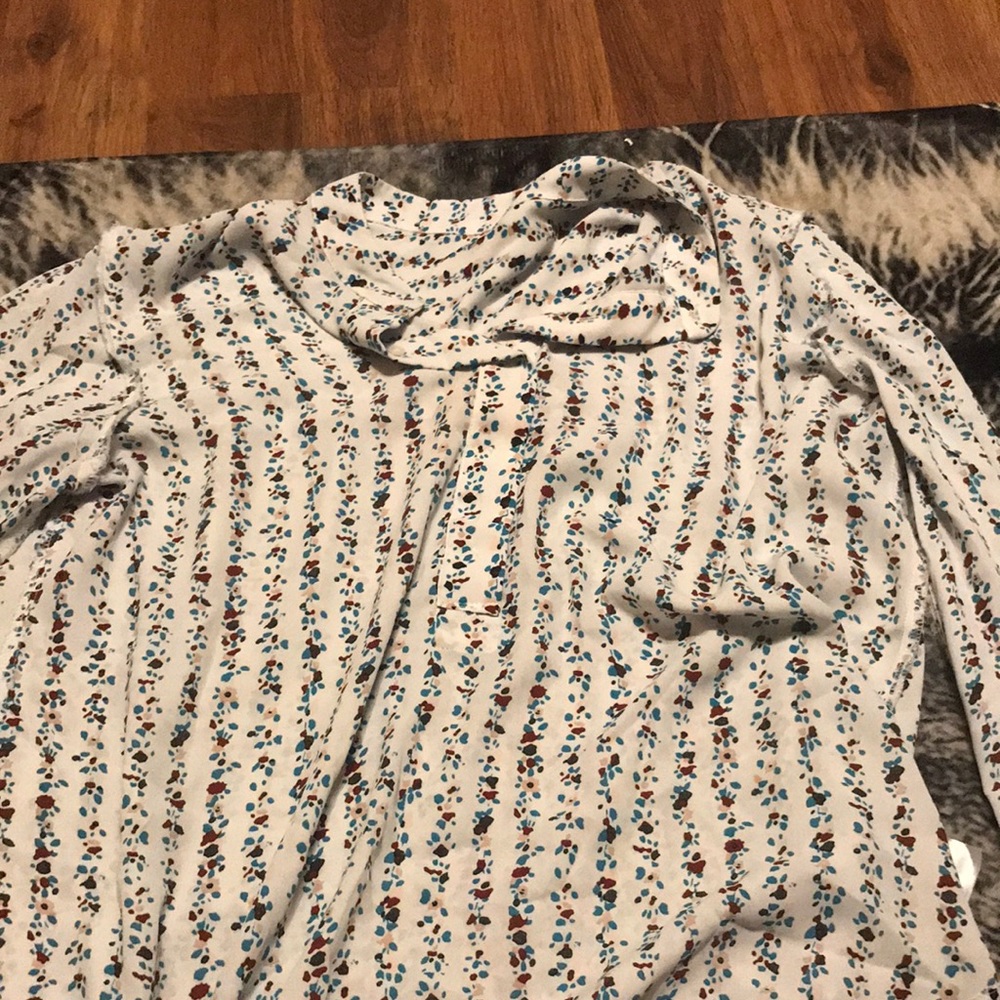 A long sleeve shirt with flowers going up and down in a designed pattern